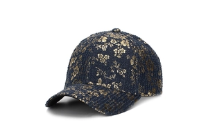 Dettaglio del cappello da baseball in tweed blu navy con eleganti motivi dorati