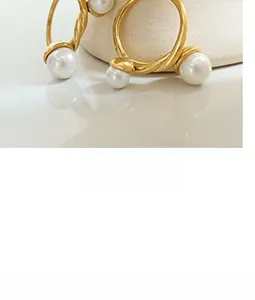 Close-up of vintage French C-shape earrings with twisted gold texture and white pearls