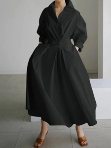 Détail d'une robe longue noire à col en V avec taille cintrée et jupe évasée élégante