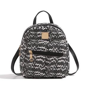 Detailed view of mini backpack with black and white snake skin pattern and gold zippers