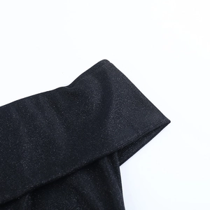 Macro shot of black glitter fabric showing shimmering texture on a glamorous evening dress
