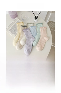 Detail of sweet ruffle edges on Japanese style crew socks in various pastel cream colors