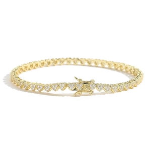 Close-up of golden heart-shaped tennis bracelet with sparkling zircons and secure clasp