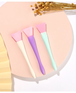 Three-piece silicone face mask brush set with soft pink fan-shaped heads and pastel handles