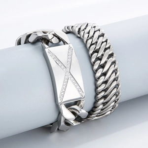 Détail macro de la chaîne gourmette en acier inoxydable avec plaque de strass en X