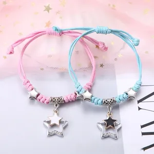 Detailansicht gewebter Paar-Armbänder mit Sternanhängern in Pink und Blau