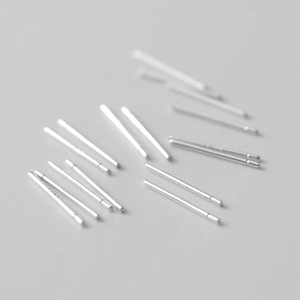 Macro detail of simple minimalist silver ear sticks scattered on a neutral surface
