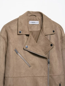 Detail of faux suede biker jacket collar with silver metallic zippers and brand label