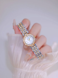 Detail of luxury two-tone women's quartz watch with diamond-encrusted bezel and metal band