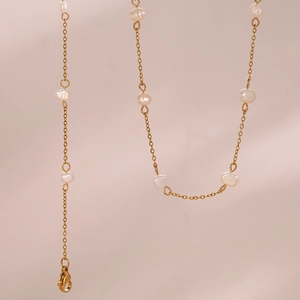 Detail of gold chain necklace featuring irregular baroque pearls and lobster clasp