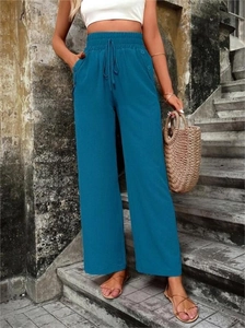 Détail du pantalon bleu sarcelle à taille haute avec tissu texturé et cordon de serrage