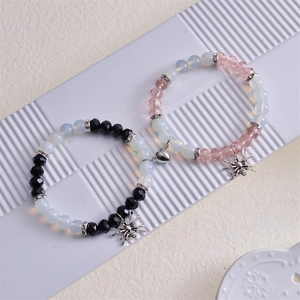 Détail de bracelets en perles avec fermoir magnétique coeur et pendentifs araignée