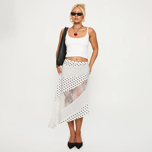 Détail de la jupe à pois avec dentelle et crop top blanc portés par un mannequin