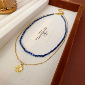 Détail du collier à deux rangs avec perles bleues et pendentif étoile doré chic