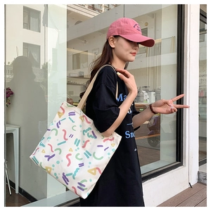 Street style shot of a cream canvas tote bag with colorful abstract geometric prints