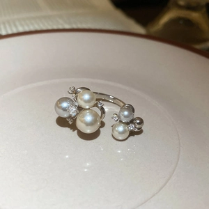 Detail of silver open ring featuring white pearls and shimmering zircon accents