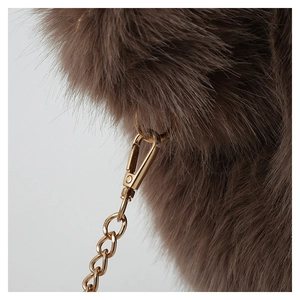Detailed macro view of brown faux fur texture with high-quality gold metal buckle and chain