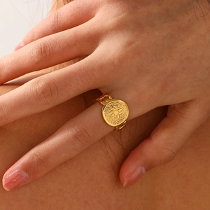 Gold eight-pointed star ring with vintage seal design on model hand, minimalist style