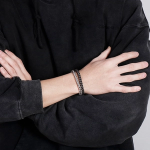 Detailed view of men's double-layer chain bracelet in silver and black titanium steel