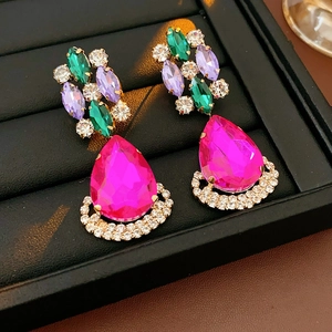 Close-up of vintage drop earrings with pink water-drop gemstone and colorful rhinestones
