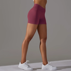 Dettaglio della vita incrociata senza cuciture su pantaloncini da yoga viola per fitness