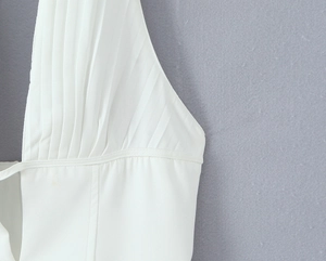 Close-up of white pleated fabric texture and stitching details on a French retro dress