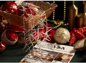 Macro detail of silver icicle Christmas ornaments with festive gold and red background