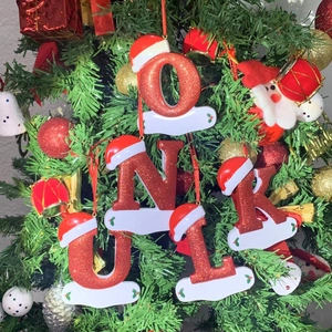 Christmas alphabet ornaments with Santa hats and glitter finish on a green festive tree