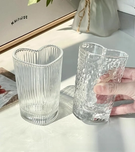 Detailed view of heart-shaped glass mugs with vertical and hammered textured surfaces
