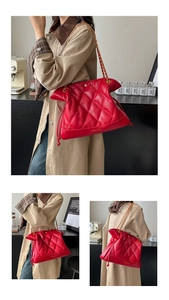 Detailed view of red quilted bucket bag with golden chain strap and drawstring closure