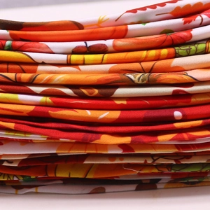 Gros plan de bandanas pour chiens empilés avec motifs d'automne de citrouilles et érable