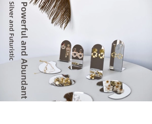 Artistic jewelry display tray with pearl earrings and necklaces on a modern mirror stand