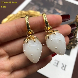 Detail shot of strawberry pearl earring showing dimensions 17mm by 46.7mm on a hand