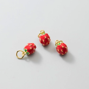 Three enamel strawberry pendants with green leaves and gold rings on white backdrop