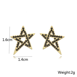 Detailed view of gold star stud earrings with black stones measuring 1.6cm by 1.4cm
