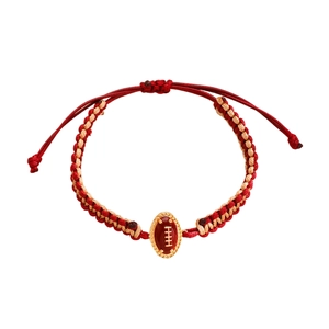 Macro detail van rood-wit gevlochten armband met gouden American football-bedel