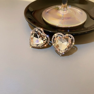 Macro shot of silver heart clip-on earrings with faceted crystals and sparkling rhinestones