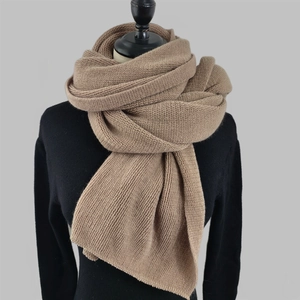 Detail shot of the chunky rib-knit texture on a warm coffee-colored winter scarf