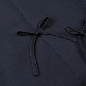 Detail shot of the tailored bow design on a navy blue woven blazer for women