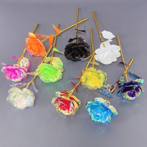 Flat lay of artificial gold foil roses in rainbow, black, and white with golden stems