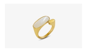 Détail d'une bague ovale dorée avec incrustation en nacre blanche et finition brossée