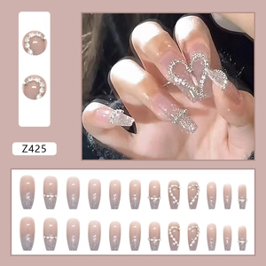 Long ballerina press-on nails with pink gradient, fine glitter, and rhinestone hearts
