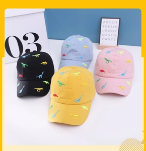 Close-up of colorful dinosaur embroidery on kids baseball caps in four pastel shades
