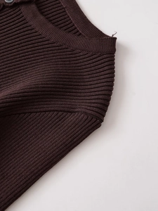 Detail of dark brown ribbed knit sweater showing the buttoned collar and fabric texture