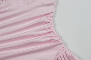Detail of pink ruched side seam on slim fit mini dress showing stitching and fabric texture