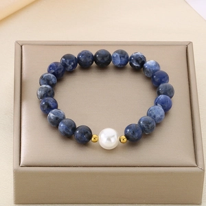 Detail of blue sodalite beads with a white accent bead on a luxury jewelry box