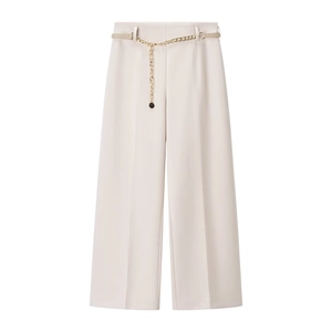 Dettaglio di pantaloni beige a gamba larga a vita alta con una cintura decorativa a catena d'oro