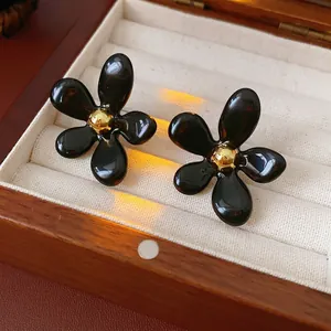 Vintage black floral earrings with gold bead center in a velvet lined wooden jewelry box