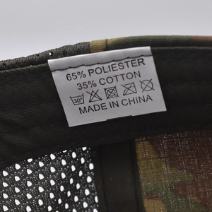Macro shot of product care label inside camo hat showing 65% polyester and 35% cotton fabric
