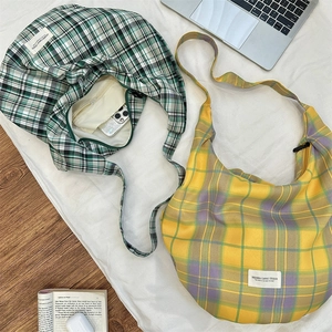 Détail de sacs hobo en toile à carreaux avec fermeture éclair et étiquette tissée